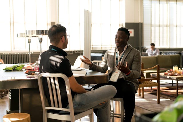 two men sit across from each other in a coaching session