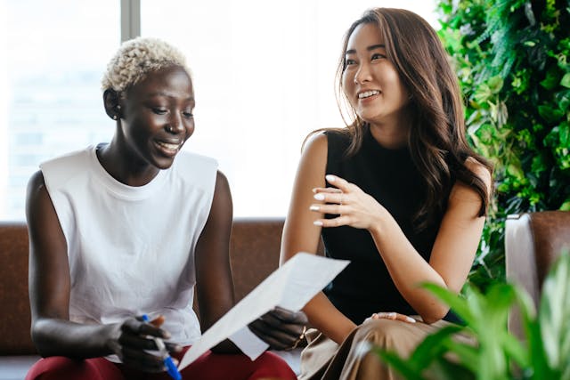 two professionally dressed women sit side by side