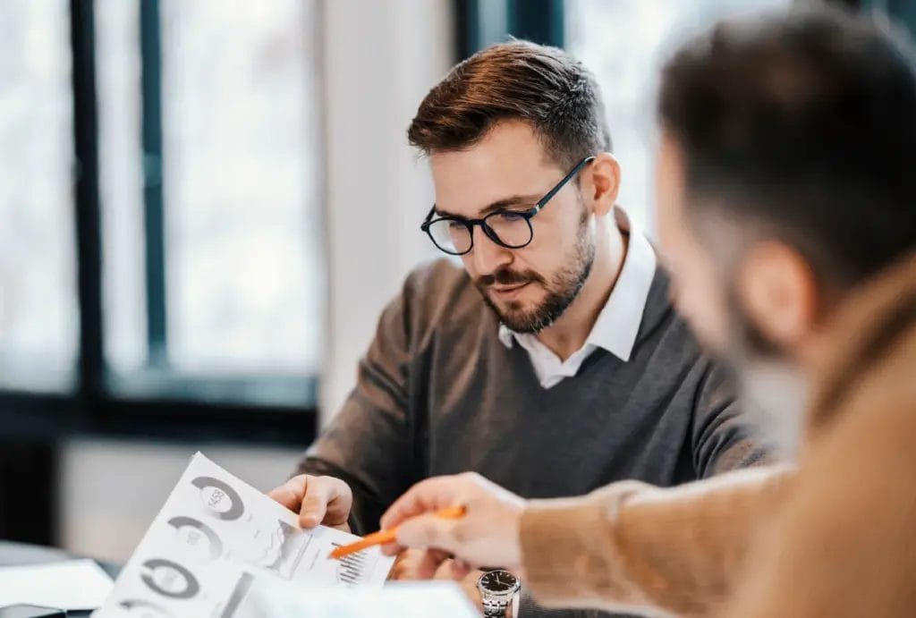 Business coach meeting with client and discussing financials.