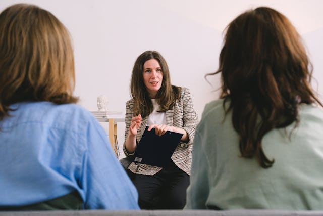 a female coach speaks to two clients