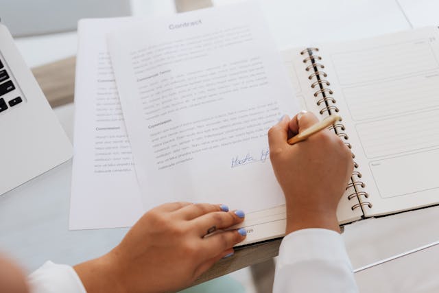 woman's hand signing a contract