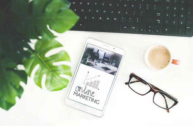 a cellphone, glasses, and cup of coffee on a desk