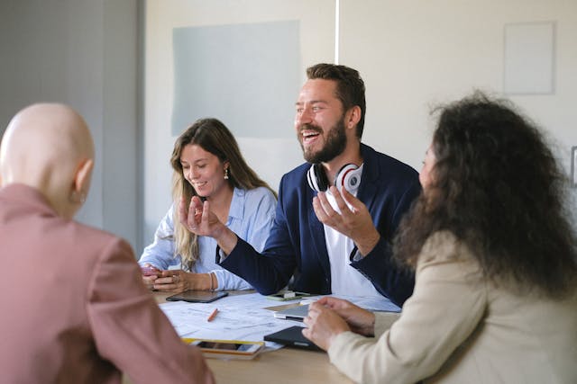 a life coach enthusiastically talks to a table of people