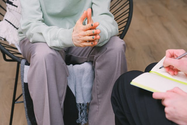 a client sitting on a chair across from a coach