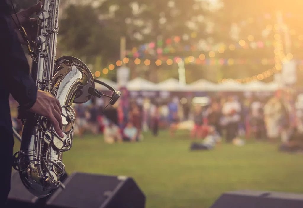 A musician plays the saxophone at a festival