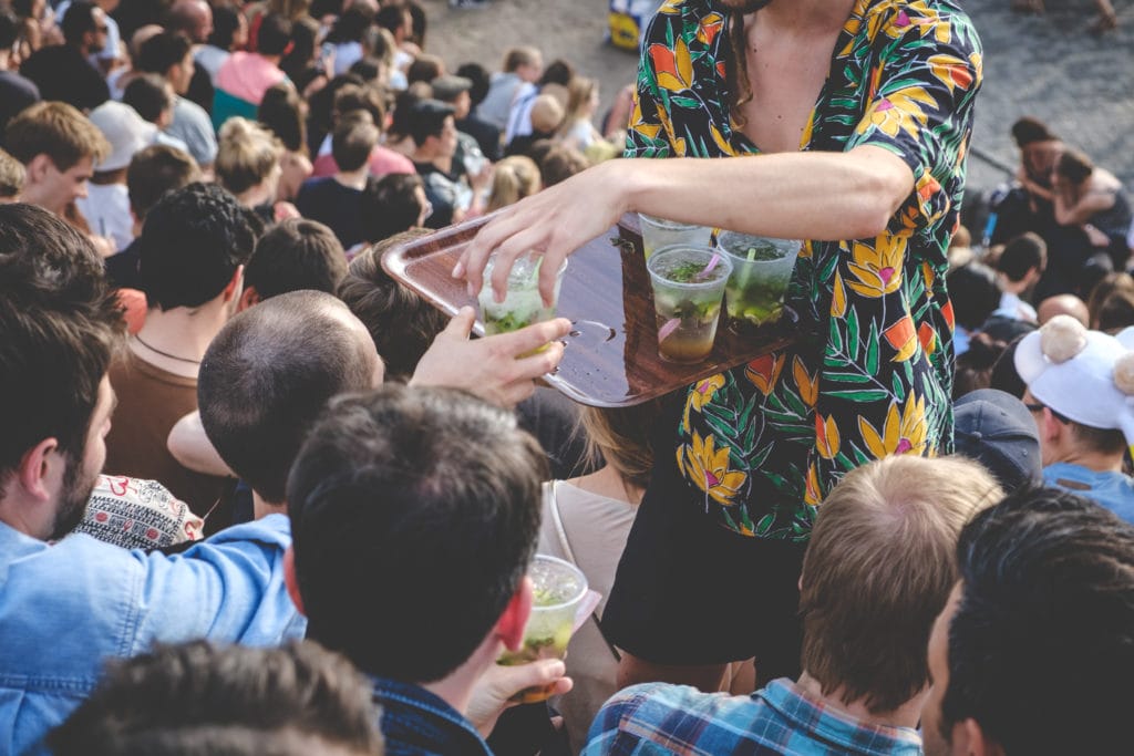 A vendor at a crowded outdoor event sells drinks.