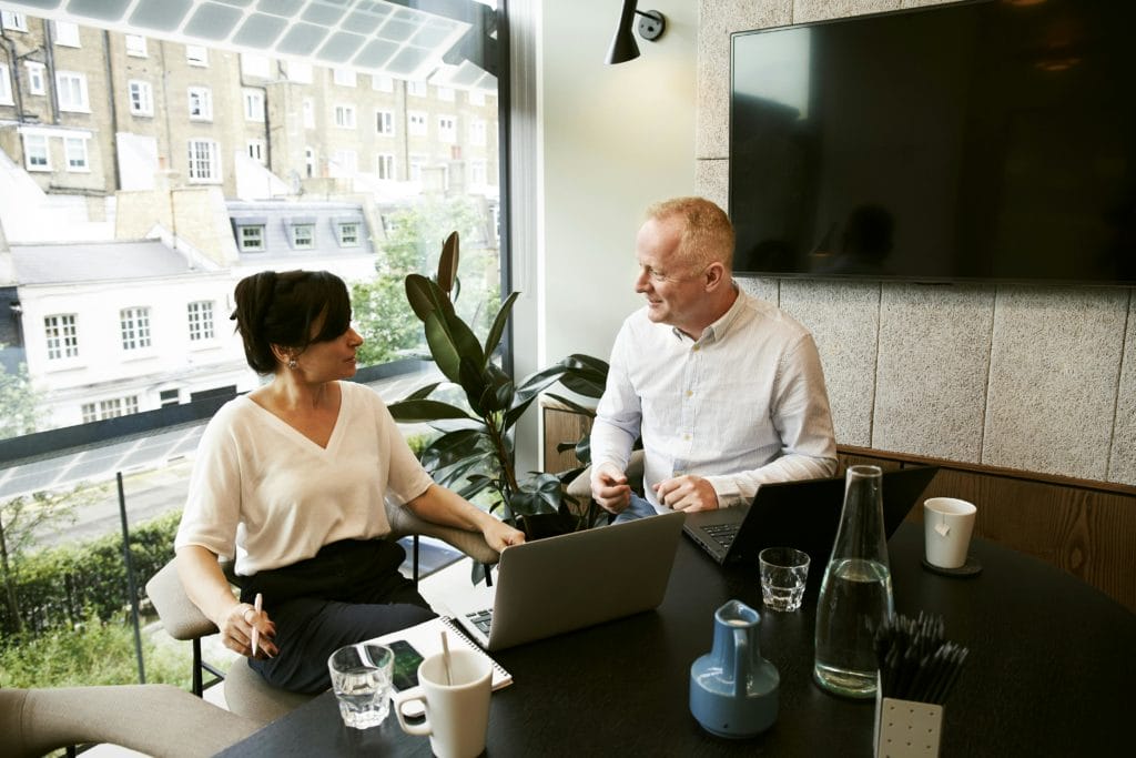 a consultant talks to a client in a brightly lit office