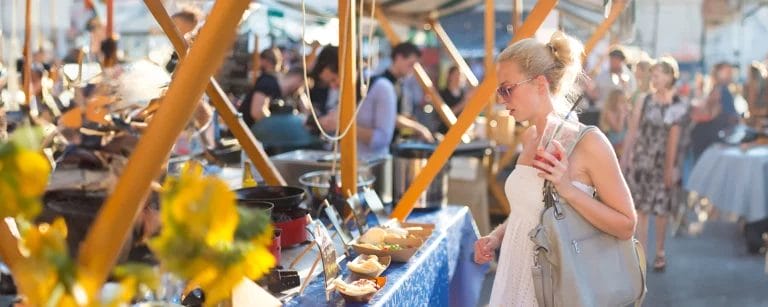 A shopper at an event buys from a vendor.