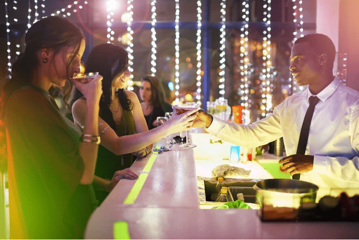 A bartender serving multiple customers.