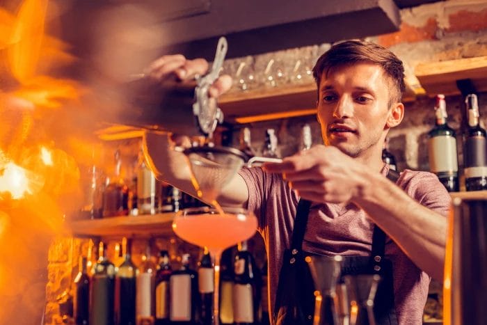Bartender serving drinks over a martini glass