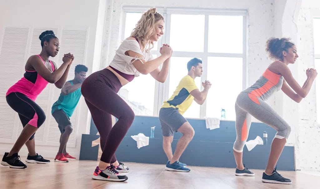 A group of Zumba students working out together to a routine in a class.