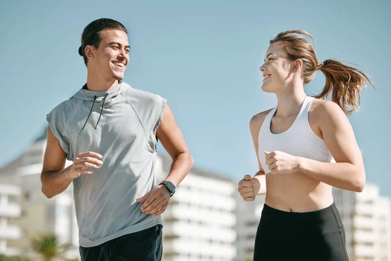 Two personal trainers run together.