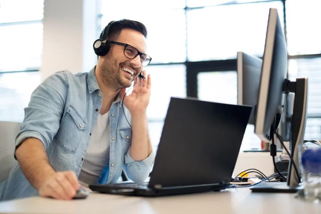 image of a male on a call in front of a computer