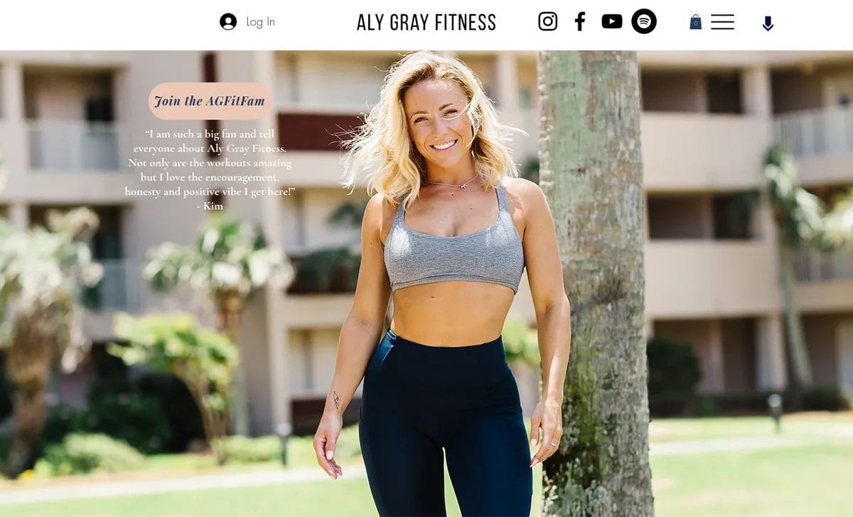 Screenshot of Aly Gray Fitness home page featuring a hero image of Aly Gray in black pants and gray sports bra, with text of a client testimonial on the left side.