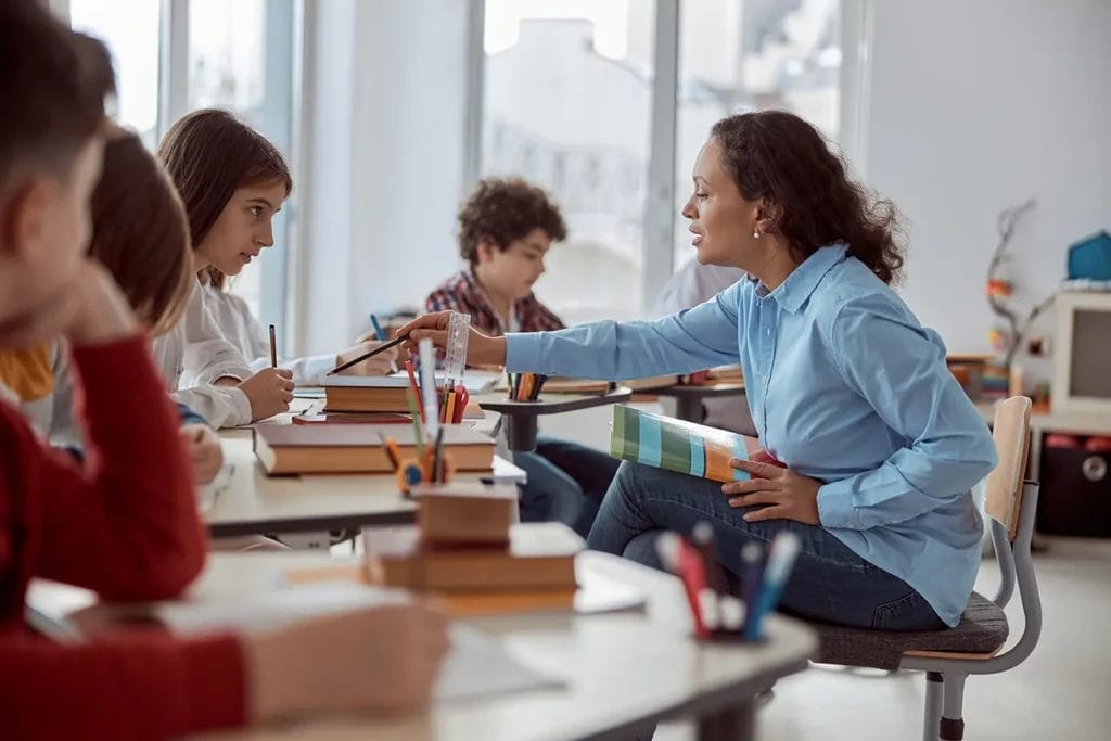 Teacher helping one student with their work.