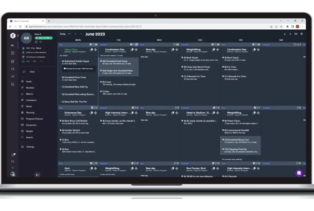 A sleek silver laptop displays the TrueCoach workout generator feature for a user named "Kate A" for June 2023. The calendar is listed from Monday to Saturday with detailed workouts for each day, titles including, "heavy duty," "combination day," "rest day," and "weightlifting." The screen is a deep gray-blue with pops of blue, green, and white text. A sidebar on the left shows stats and other features, such as chat, goals, nutrition, and more.