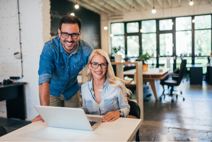 Two business professionals sitting at a laptop.