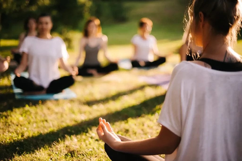 Outdoor meditation group sitting peacefully.