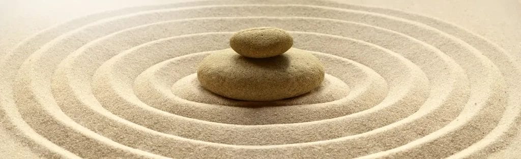 Sand ripples surrounding stacked rocks.