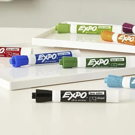 Different colored dry erase markers on a neutral background.