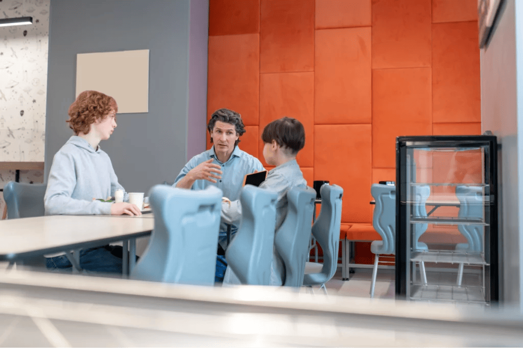 Teacher having a serious conversation with two students.