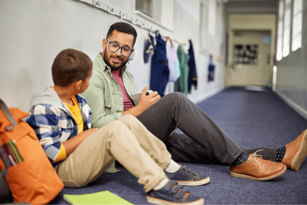 Teacher sits in hallway to talk to young student