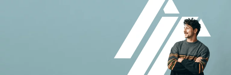 An entrepreneur standing with his arms crossed, smiling, in front of the Insurance Canopy logo