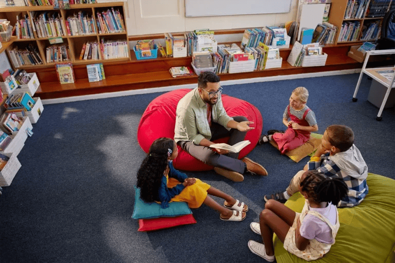 Teacher with a group of students reading a book