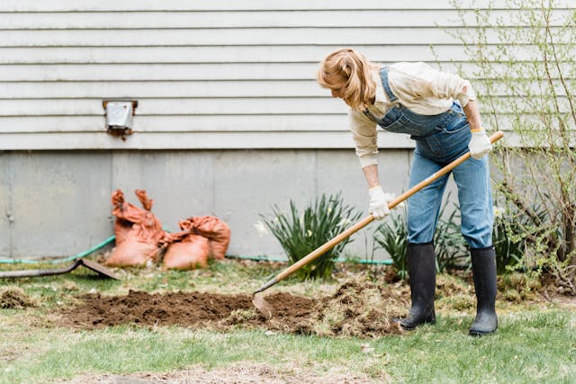 a woman in overalls tends to a lawn