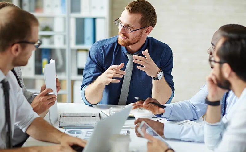 Image of men talking on a table