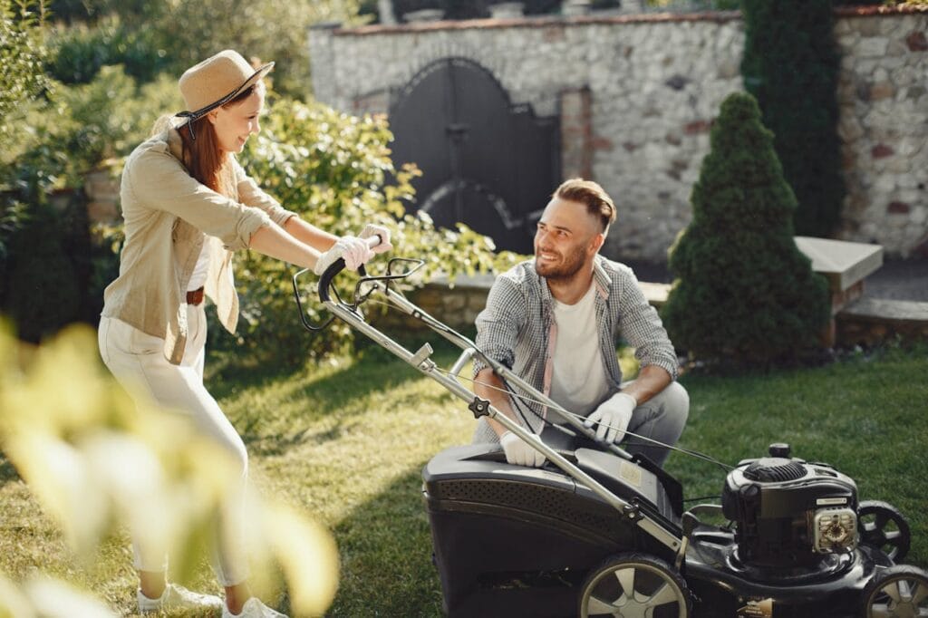 Woman in Brown Long Sleeve Shirt Holding Lawn Mower