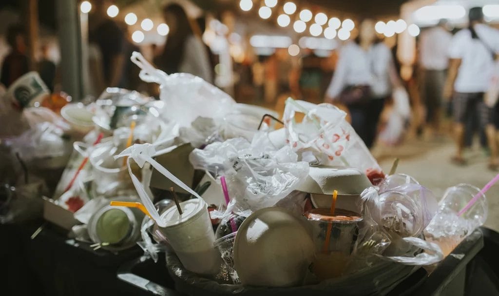 Food garbage at a festival with blurred people in the background.