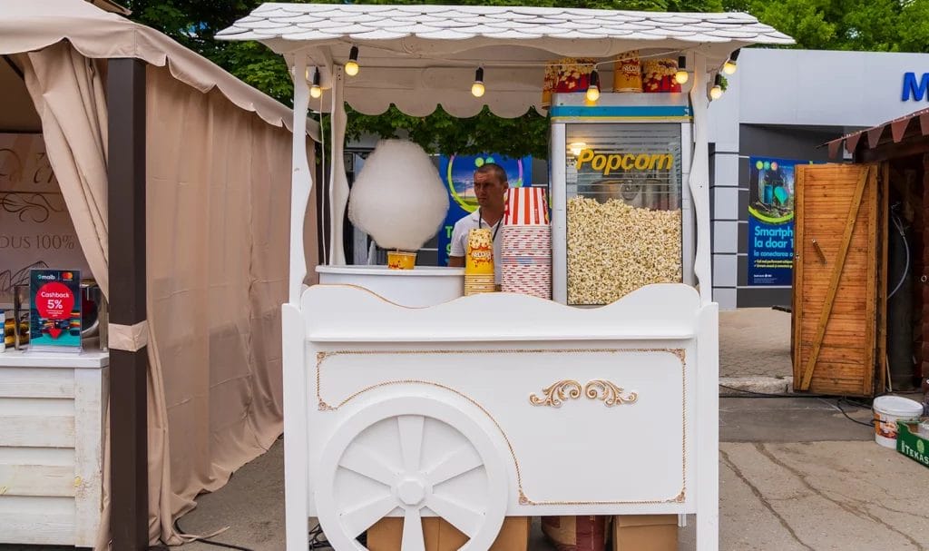 A vendor operating a popcorn stall at a street food festival.