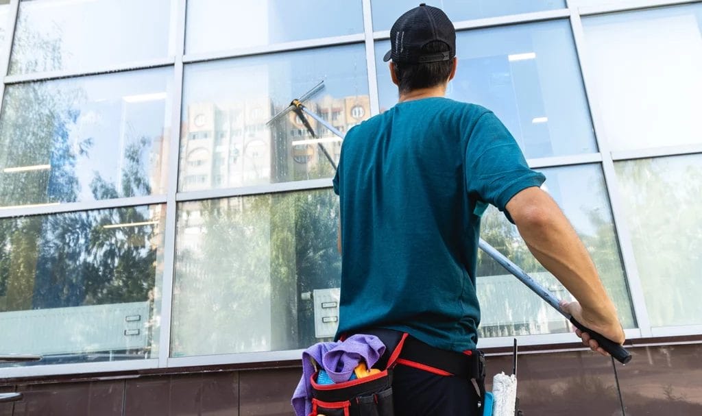 An employee of a professional cleaning service washes the facade and windows with special devices.