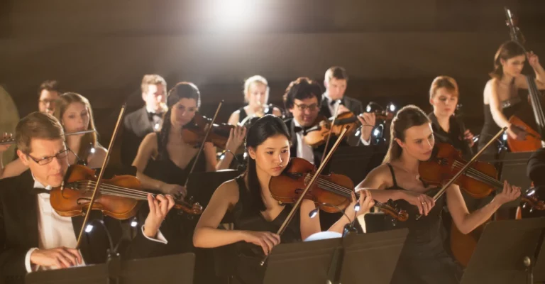 An orchestra playing a symphony at a concert.