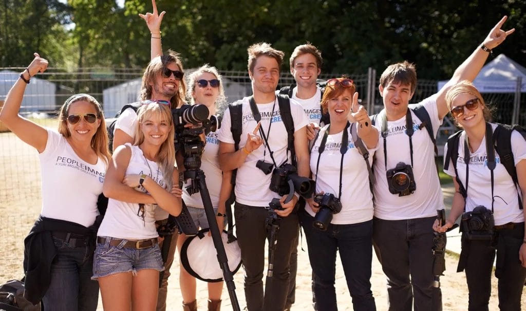 Group of employees working a vendor trade show booth together pose for a photo.