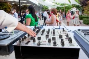 A wedding DJ spinning at an outdoor ceremony.