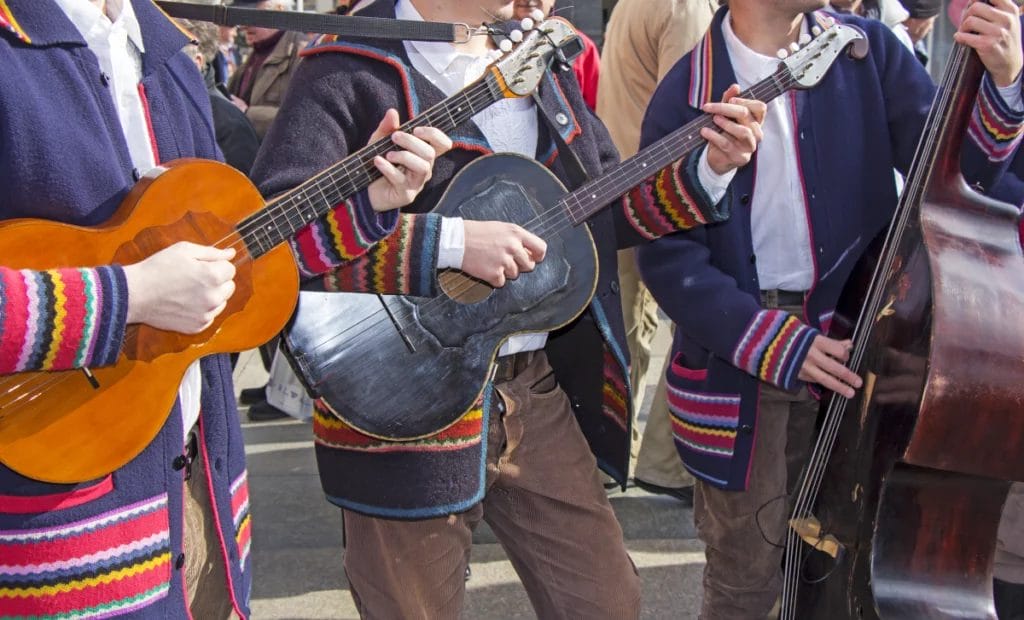 A group of traditional Croatian musicians in traditional clothes, playing in a city street.