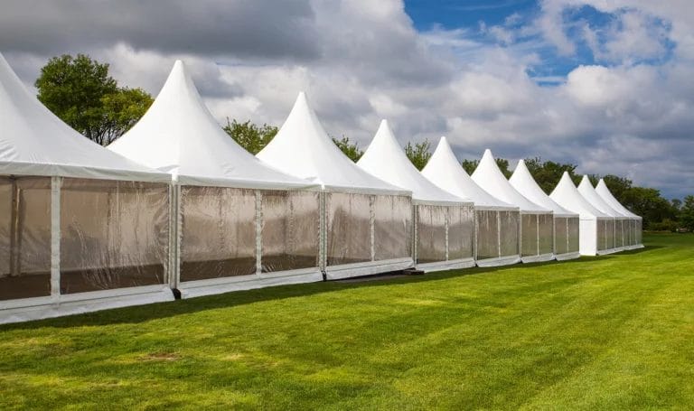 Row of empty pop-up outdoor tents for a vendor event.