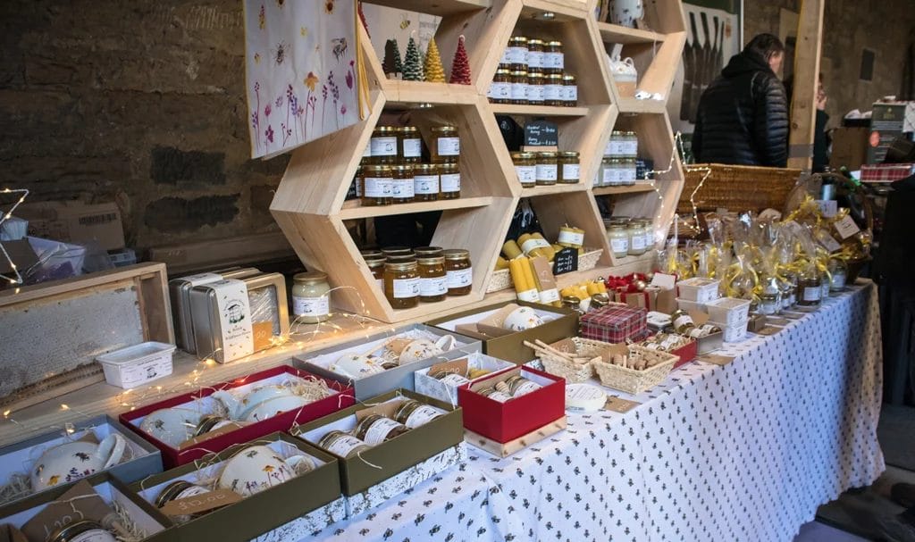 Handmade preserves and food items on display on a stall at a food market.