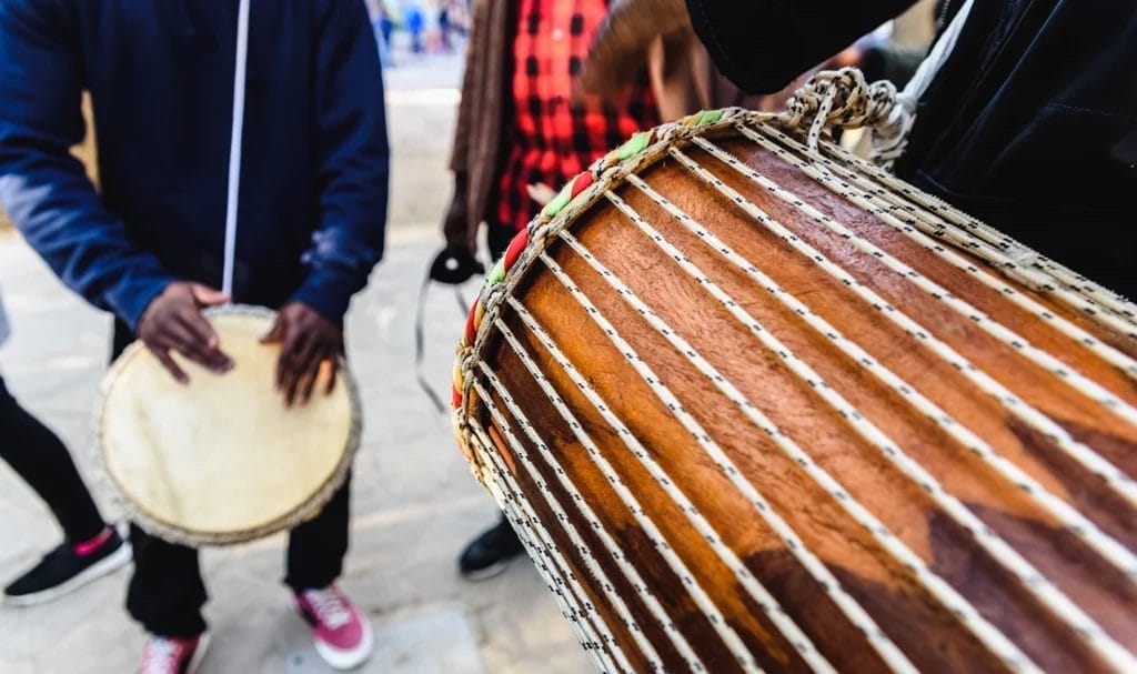 Close-up look at street performers playing bongos at an outdoor street festival.