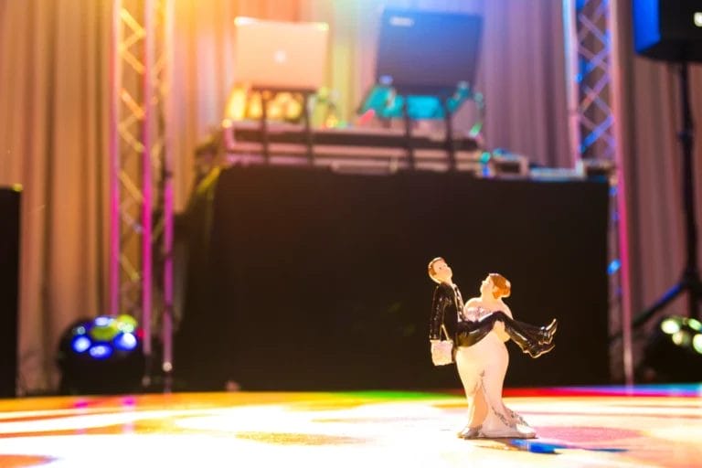 A mini couple figurine by a DJ booth.