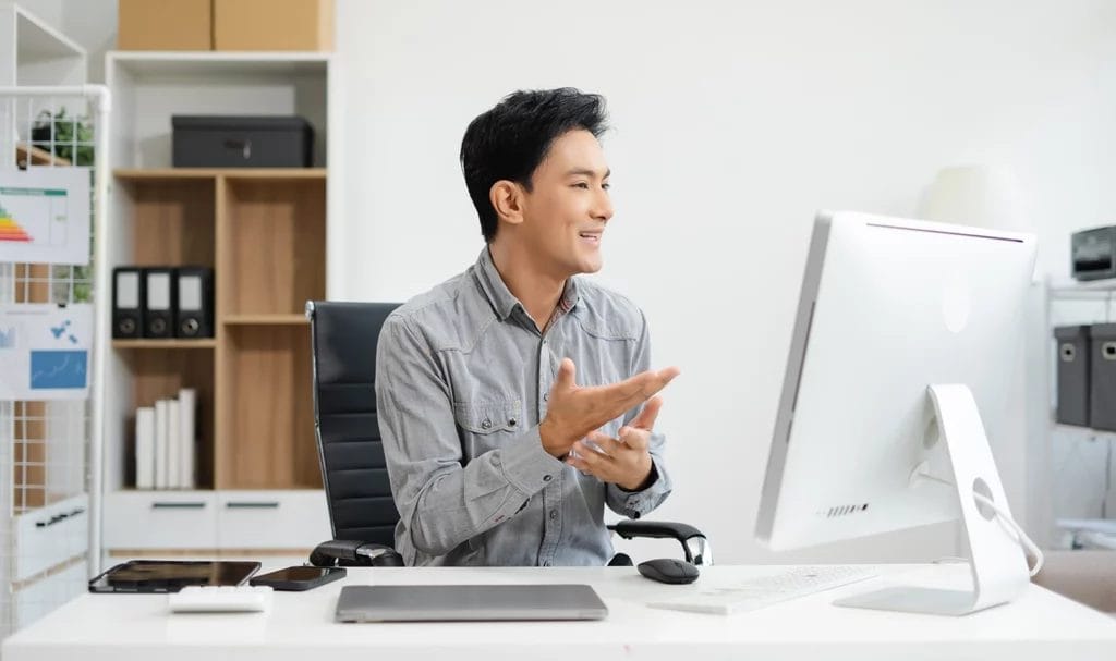 Entrepreneur speaking in a meeting in a home office, working online with laptop and documents.