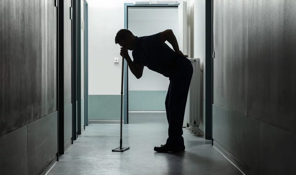 Man suffering from back ache while mopping.