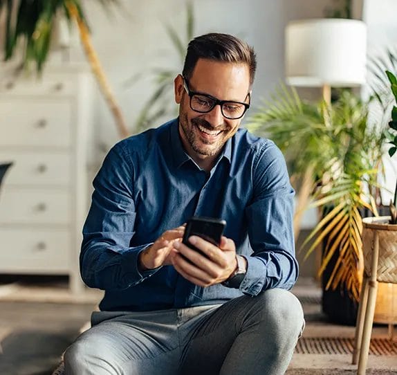 guy in blue shirt holding a phone.