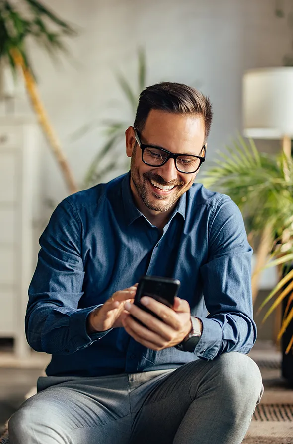 guy in blue shirt holding a phone.