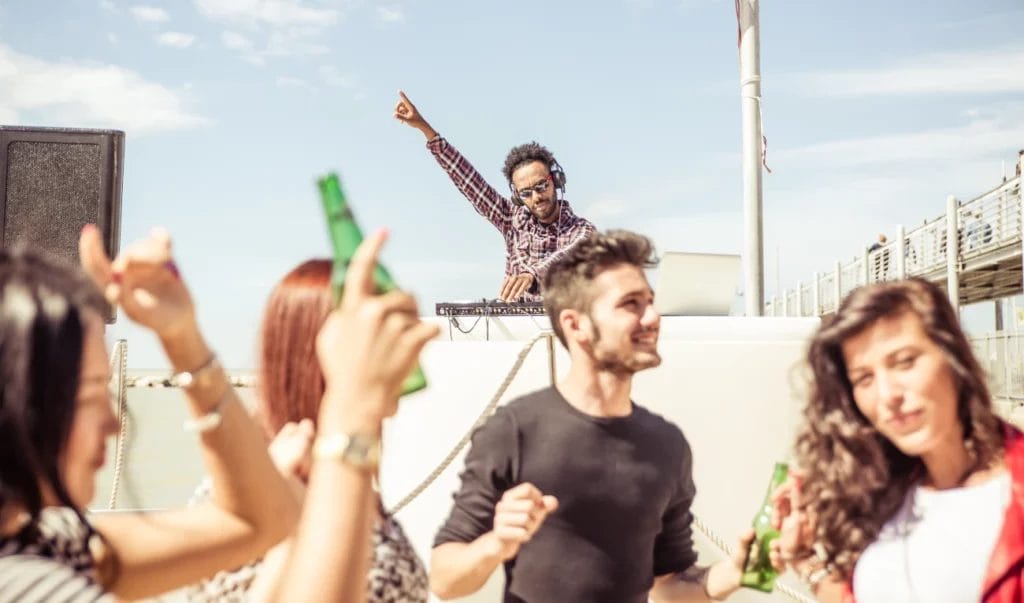 A DJ turning it up at a beach party.