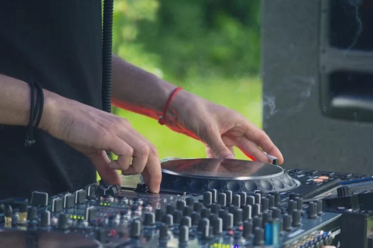 A DJ spinning tracks at a park concert.