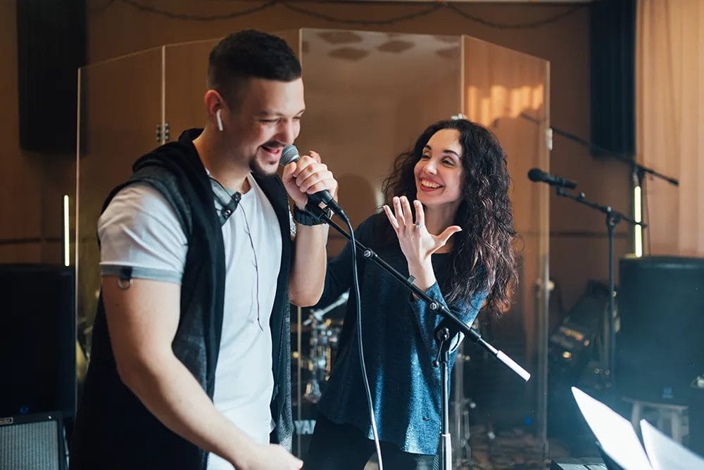 Vocal coach laughs with a vocal student during a singing lesson