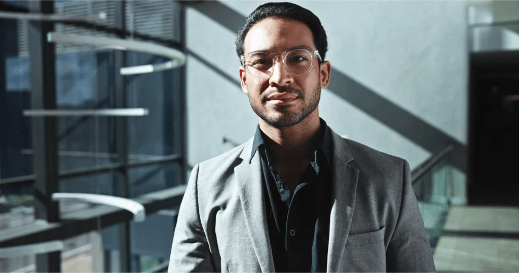 Portrait of a confident business professional in an office building with high-contrast shadows and lighting.
